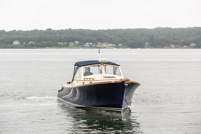 Slide: The Image of 1998 Hinckley Picnic Boat cruising on calm waters near a forested shoreline. - 8