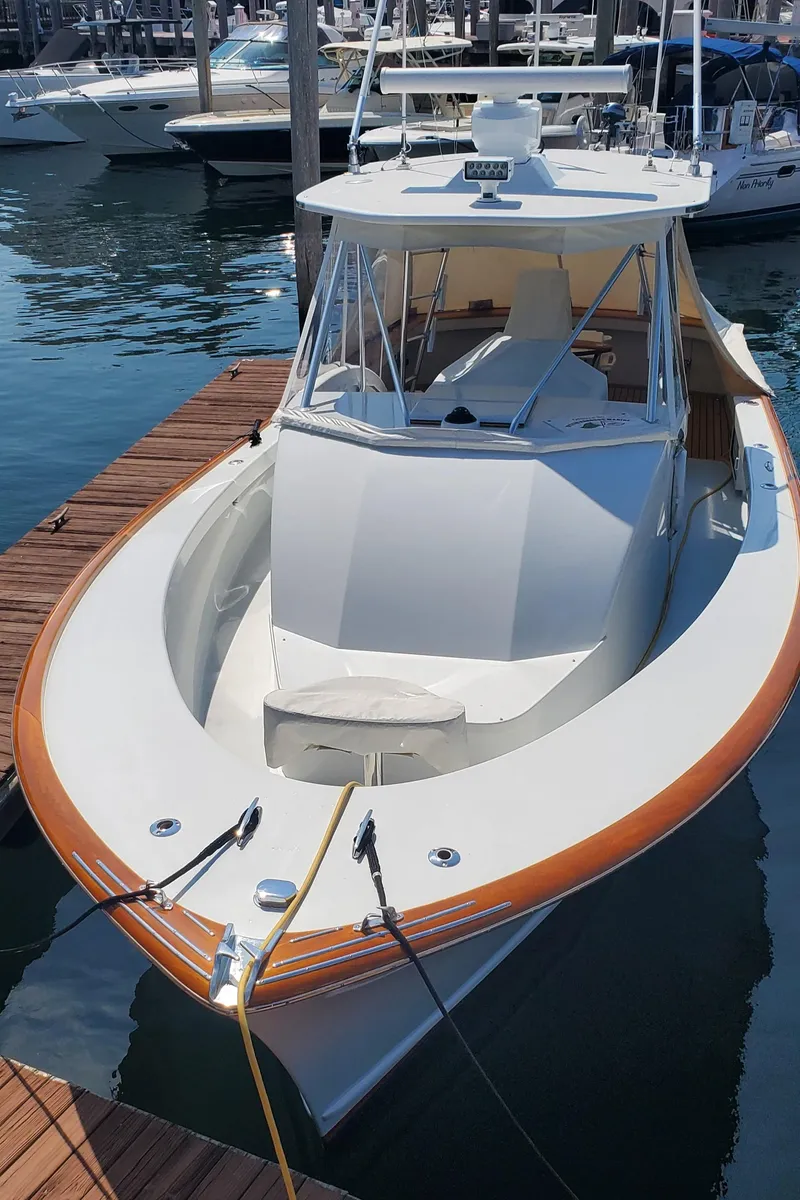 Slide: The Image of 1985 Rybovich 32 Express Walkaround Sportfish docked at marina, showcasing sleek design and craftsmanship. - 10