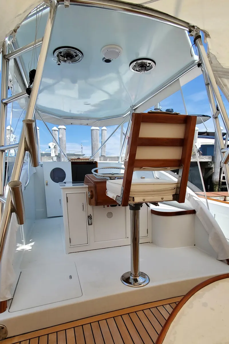 Slide: The Image of 1985 Rybovich 32 Express Walkaround Sportfish boat interior with helm chair and fishing equipment. - 13