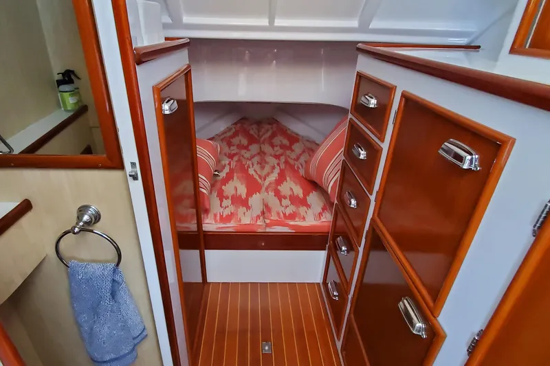 Slide: The Image of 1985 Rybovich 32 Express Walkaround Sportfish cabin with wood cabinetry and cozy bed. - 18