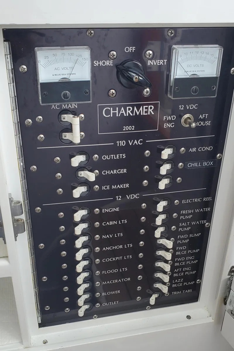 Slide: The Image of Electrical panel of a 1985 Rybovich 32 Express Walkaround Sportfish boat, featuring various switches and meters. - 20