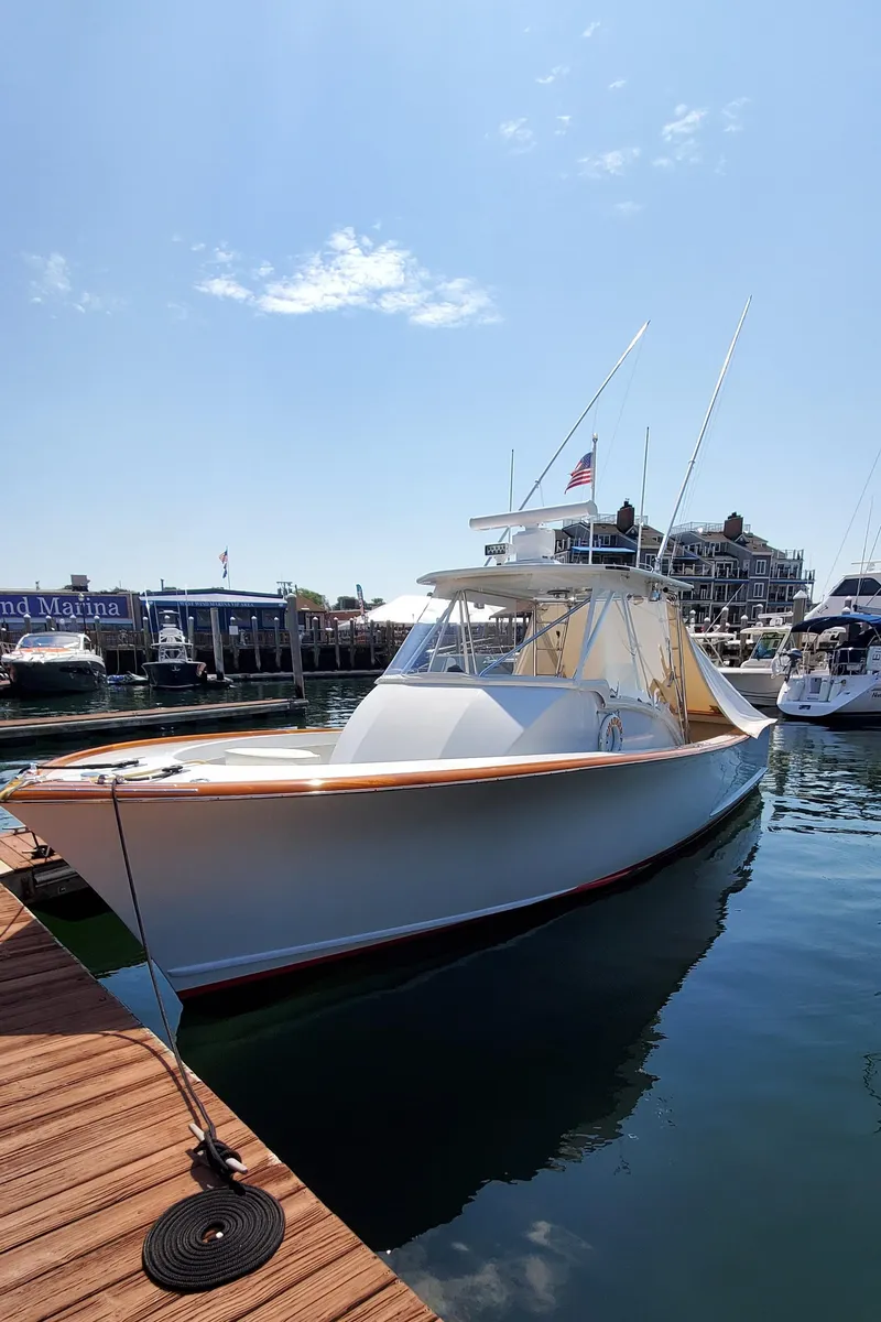 Slide: The Image of 1985 Rybovich 32 Express Walkaround Sportfish docked at marina under clear sky. - 3