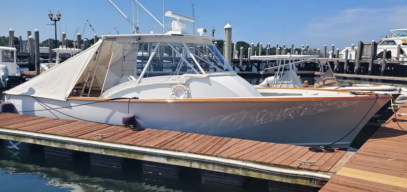 Slide: The Image of 1985 Rybovich 32 Express Walkaround Sportfish docked at marina under clear blue sky. - 4