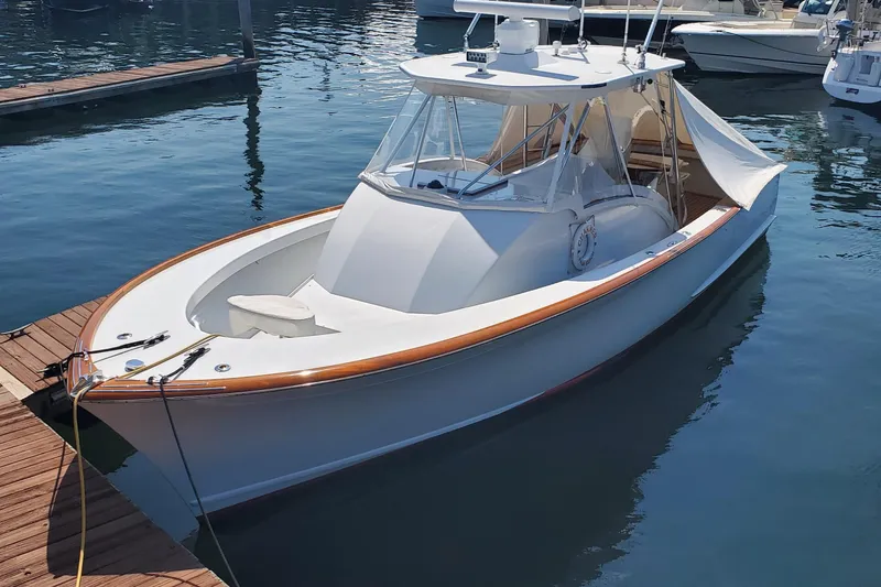 Slide: The Image of 1985 Rybovich 32 Express Walkaround Sportfish docked in marina, sleek design, wooden accents. - 9