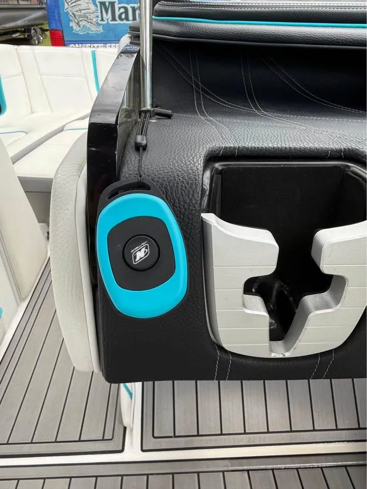 Slide: The Image of 2020 Nautique Super Air Nautique G21 interior with cup holder and blue remote control. - 17