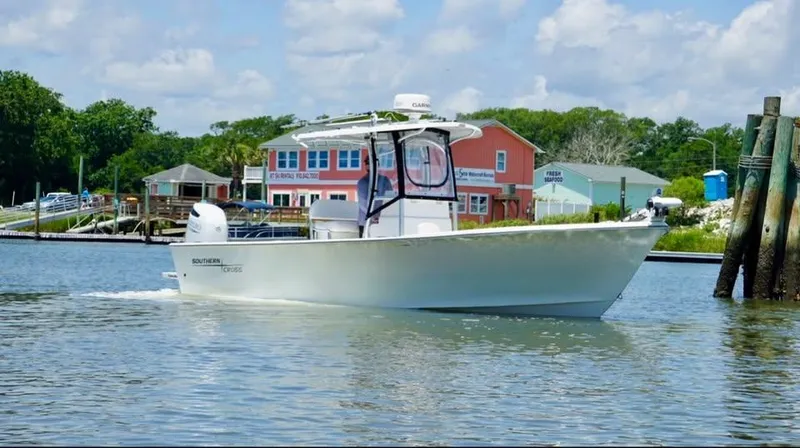 Slide: The Image of Southern Cross 25 boat cruising near colorful waterfront buildings, 2022 model. - 2