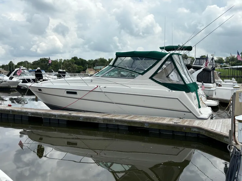 The Image of 1997 Maxum 3200 SCR boat docked at marina under cloudy sky. - 1