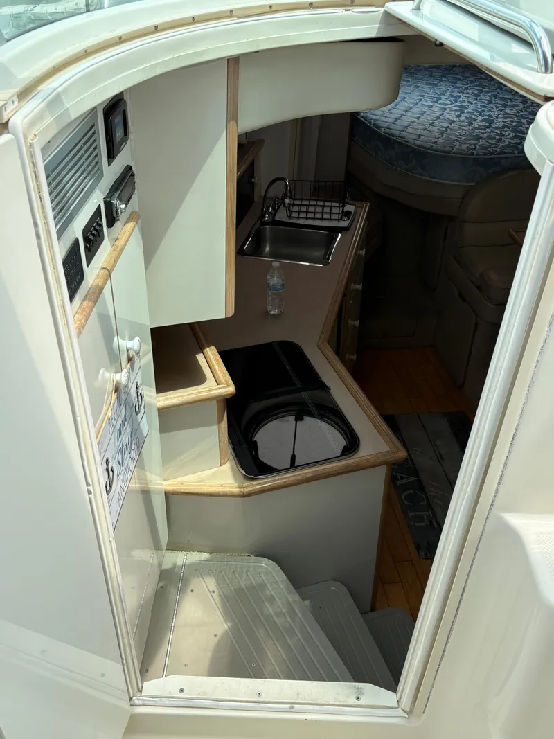 Slide: The Image of Interior of 1997 Maxum 3200 SCR boat, featuring compact kitchen and sleeping area. - 15