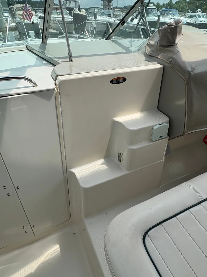 Slide: The Image of 1997 Maxum 3200 SCR boat interior with seating and steps, docked at a marina. - 18