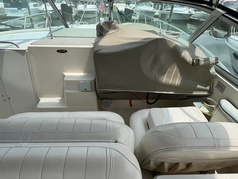 Slide: The Image of Interior of a 1997 Maxum 3200 SCR boat with covered dashboard and white seating. - 19