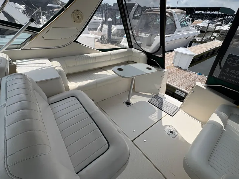 Slide: The Image of Interior of 1997 Maxum 3200 SCR yacht with white seating and table, docked at marina. - 21