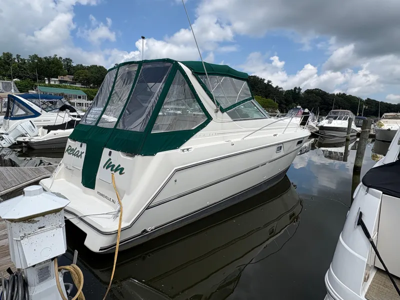 Slide: The Image of 1997 Maxum 3200 SCR boat docked with green canopy, reflecting on calm water. - 4