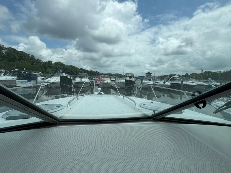 Slide: The Image of 1997 Maxum 3200 SCR boat docked in a marina under cloudy skies. - 5