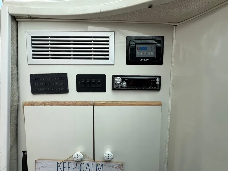 Slide: The Image of 1997 Maxum 3200 SCR boat interior with control panel, switches, and stereo system. - 7