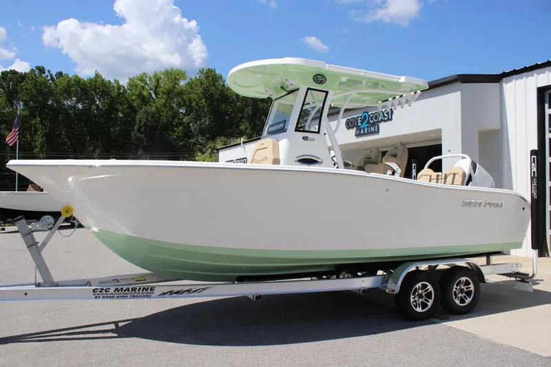 Slide: The Image of 2026 Sea Pro 245 Sandbar boat on trailer, displayed outdoors at a marine dealership. - 11