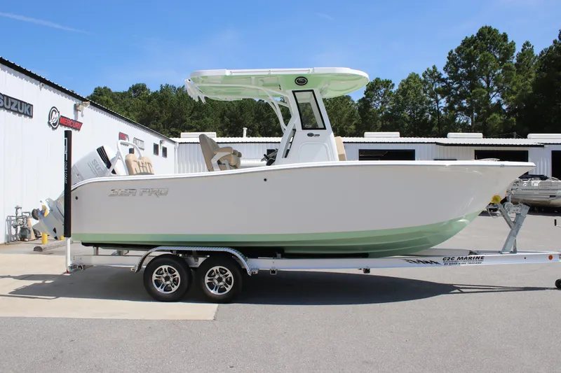 Slide: The Image of 2026 Sea Pro 245 Sandbar boat on trailer, parked outside marine dealership. - 13