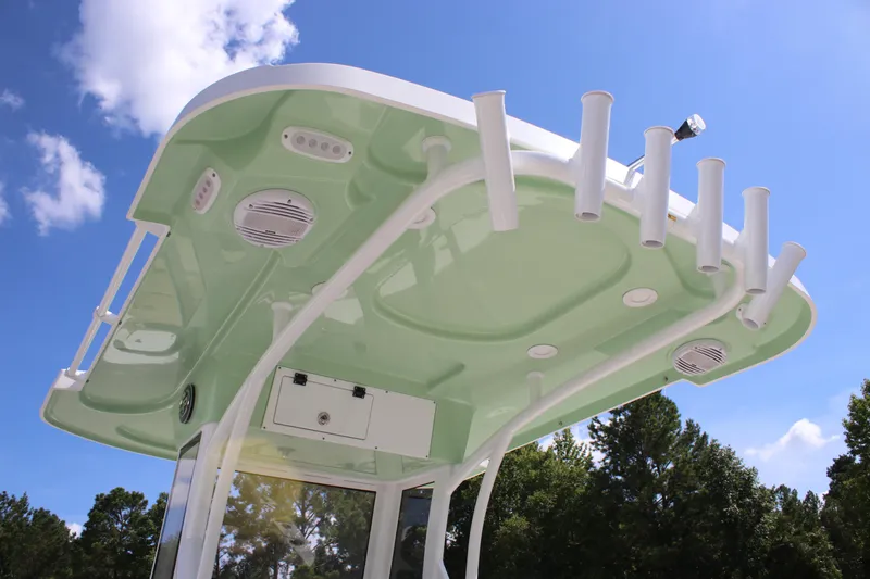 Slide: The Image of T-top of 2026 Sea Pro 245 Sandbar boat with rod holders and speakers against blue sky. - 43