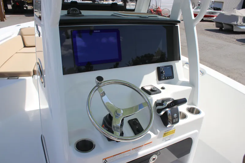 Slide: The Image of 2026 Sea Pro 245 Sandbar boat helm with steering wheel and navigation display. - 45