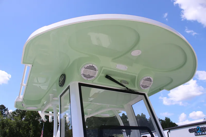Slide: The Image of 2026 Sea Pro 245 Sandbar boat with green canopy and speakers, under a clear blue sky. - 46