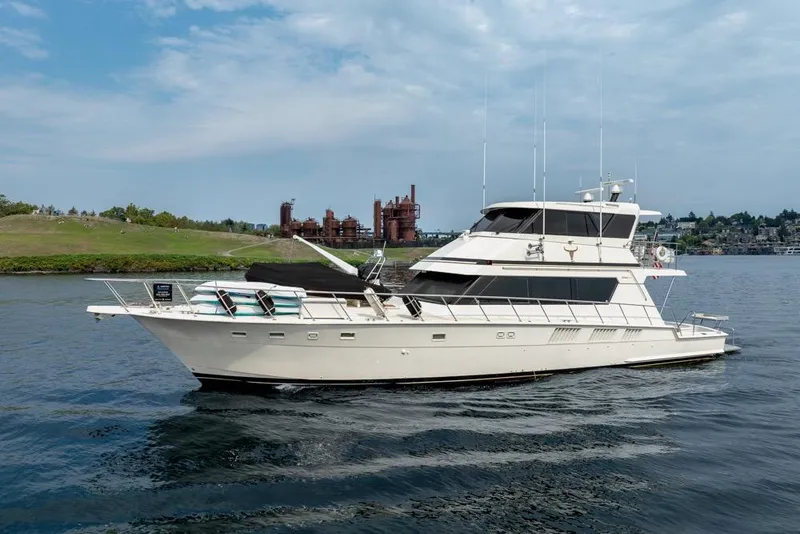 Slide: The Image of 1988 Hatteras 65 Sportfish yacht cruising on a scenic waterway. - 1