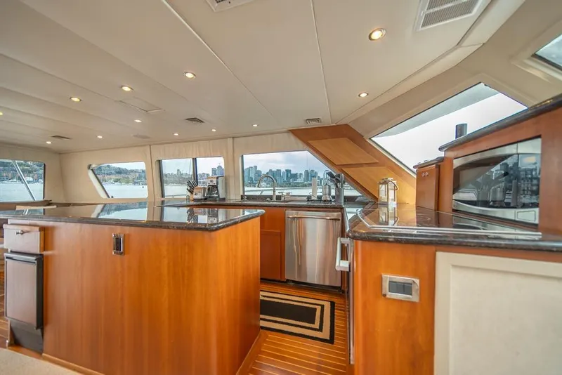 Slide: The Image of Luxurious interior of 1988 Hatteras 65 Sportfish yacht with modern kitchen and panoramic windows. - 18