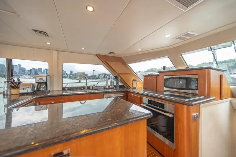 Slide: The Image of Luxurious kitchen interior of 1988 Hatteras 65 Sportfish yacht with city skyline view. - 19