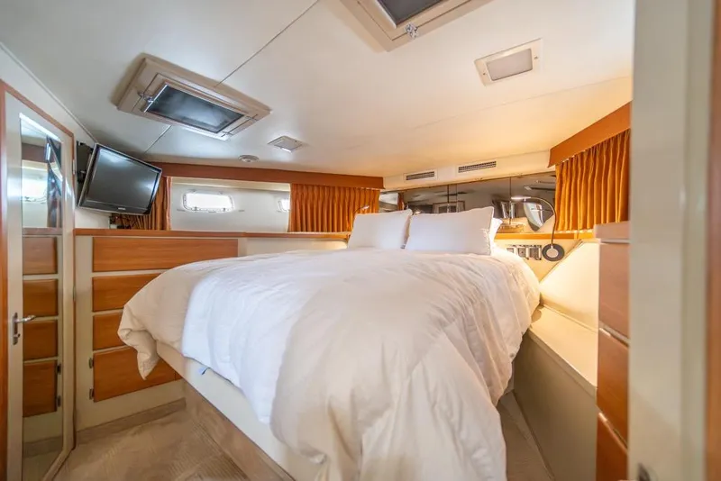 Slide: The Image of Luxurious bedroom interior of 1988 Hatteras 65 Sportfish yacht with cozy bedding. - 23