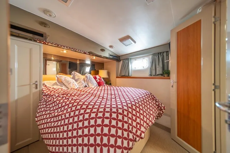 Slide: The Image of Luxurious bedroom interior of 1988 Hatteras 65 Sportfish yacht with patterned bedding. - 28