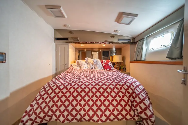 Slide: The Image of Cozy bedroom interior of 1988 Hatteras 65 Sportfish yacht with patterned bedding. - 29