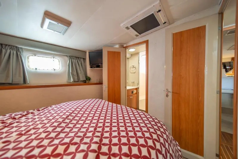 Slide: The Image of Cozy bedroom interior of 1988 Hatteras 65 Sportfish yacht with patterned bedding. - 32