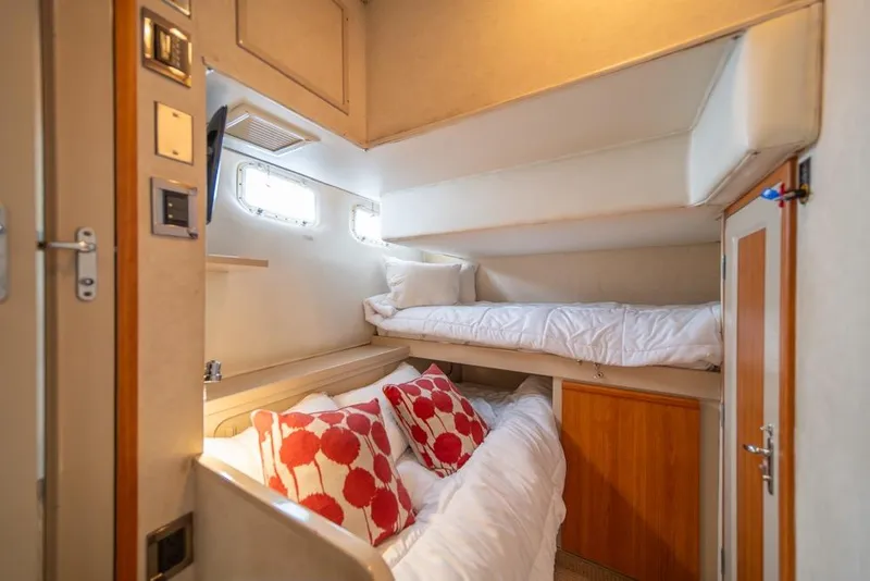 Slide: The Image of Cozy cabin interior of 1988 Hatteras 65 Sportfish with bunk beds and vibrant pillows. - 34