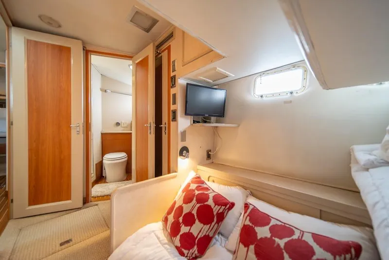 Slide: The Image of Cozy cabin interior of 1988 Hatteras 65 Sportfish with bed, TV, and ensuite bathroom. - 35