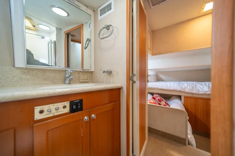 Slide: The Image of Interior of 1988 Hatteras 65 Sportfish yacht showing bathroom and cozy bedroom. - 36