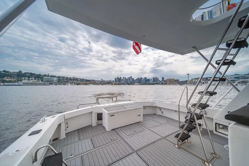 Slide: The Image of 1988 Hatteras 65 Sportfish yacht deck with city skyline view, overcast sky. - 37