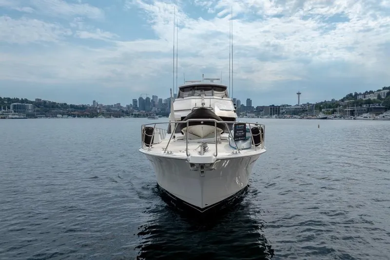 Slide: The Image of 1988 Hatteras 65 Sportfish yacht on water with city skyline in background. - 4