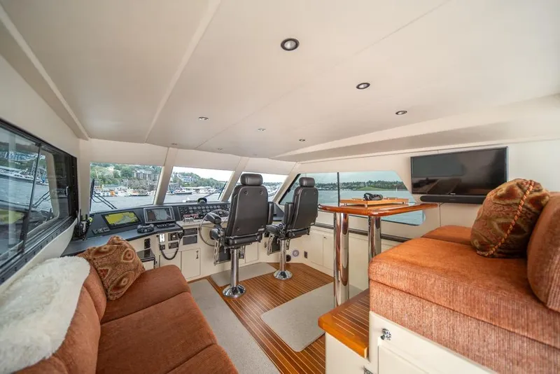 Slide: The Image of Interior of 1988 Hatteras 65 Sportfish yacht with helm, seating, and panoramic windows. - 42