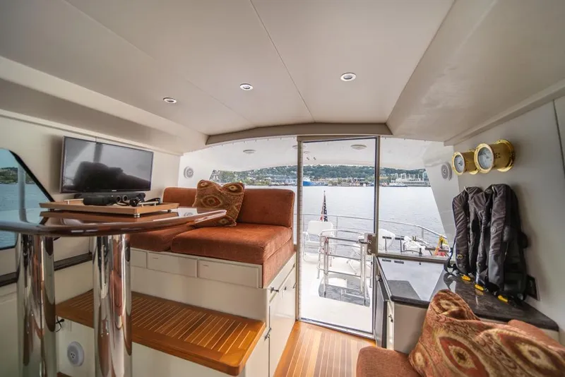 Slide: The Image of Interior of 1988 Hatteras 65 Sportfish yacht with seating, TV, and lake view. - 46