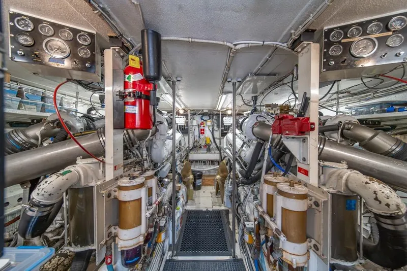 Slide: The Image of Engine room of 1988 Hatteras 65 Sportfish yacht, showcasing complex machinery and equipment. - 47