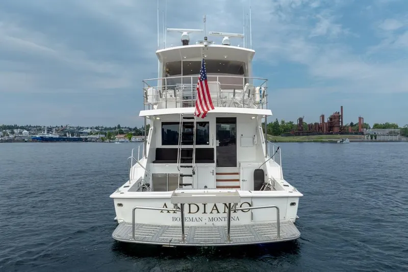 Slide: The Image of 1988 Hatteras 65 Sportfish yacht on water, rear view with American flag. - 5