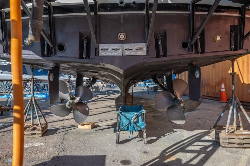 Slide: The Image of 1988 Hatteras 65 Sportfish boat propellers and hull in dry dock. - 52