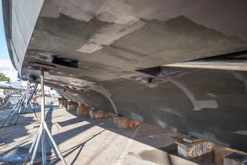 Slide: The Image of 1988 Hatteras 65 Sportfish boat hull on stands, undergoing maintenance. - 57