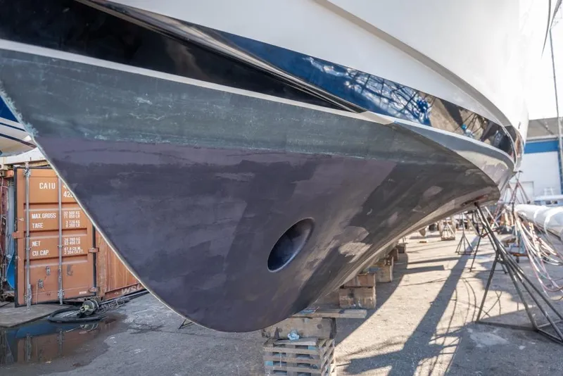 Slide: The Image of 1988 Hatteras 65 Sportfish boat hull in dry dock, undergoing maintenance. - 63