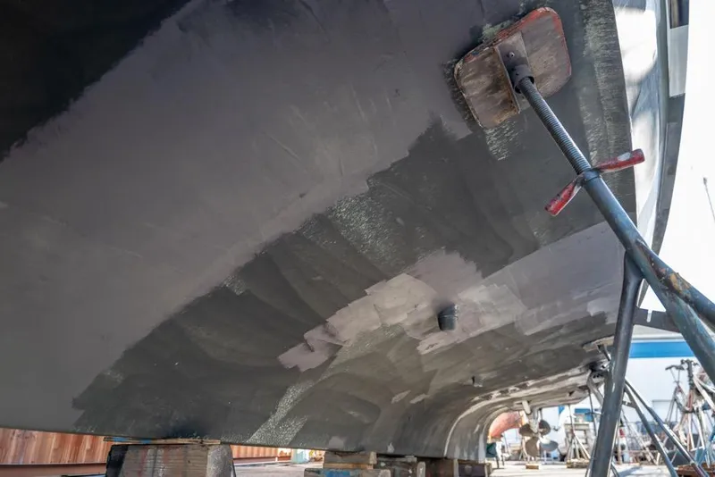 Slide: The Image of 1988 Hatteras 65 Sportfish boat hull under maintenance in a shipyard. - 65