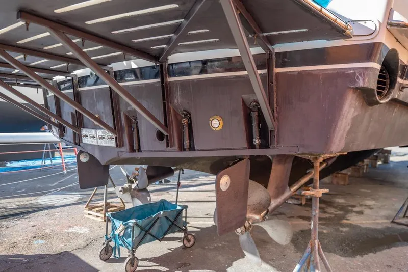 Slide: The Image of 1988 Hatteras 65 Sportfish boat under maintenance, showing propeller and hull details. - 69