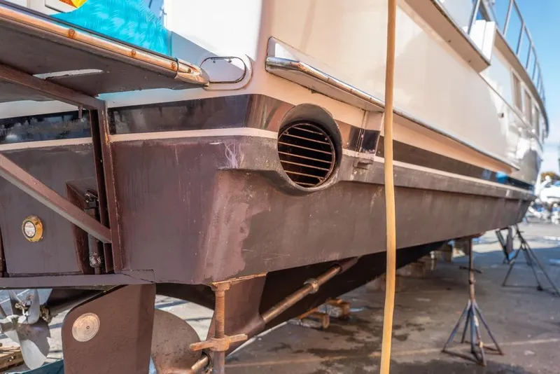 Slide: The Image of 1988 Hatteras 65 Sportfish yacht on dry dock, showing hull and propeller details. - 73