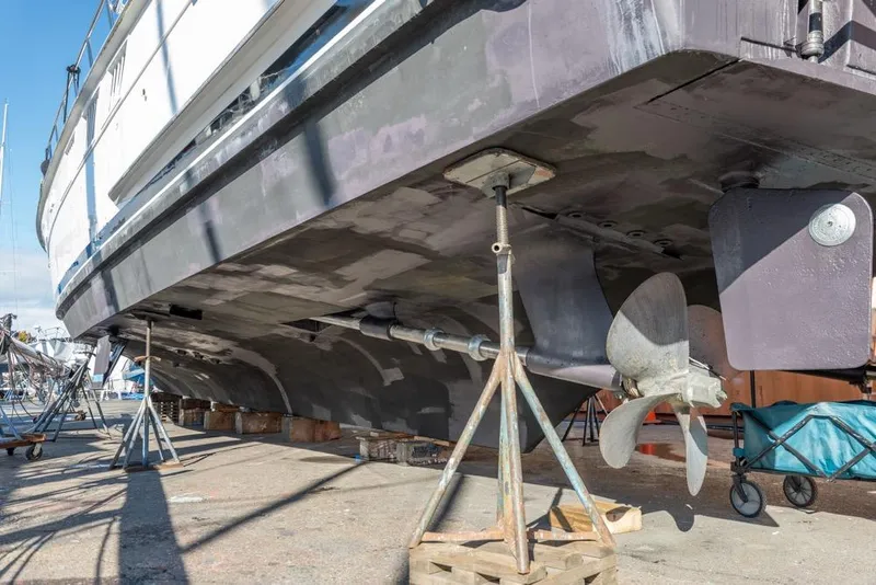 Slide: The Image of 1988 Hatteras 65 Sportfish yacht on dry dock, showing hull and propeller details. - 74