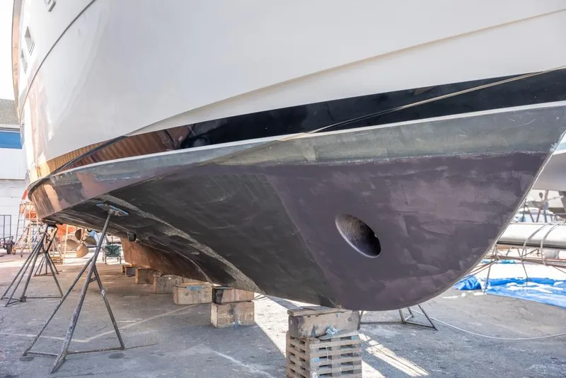 Slide: The Image of 1988 Hatteras 65 Sportfish yacht under maintenance, hull view on stands. - 79