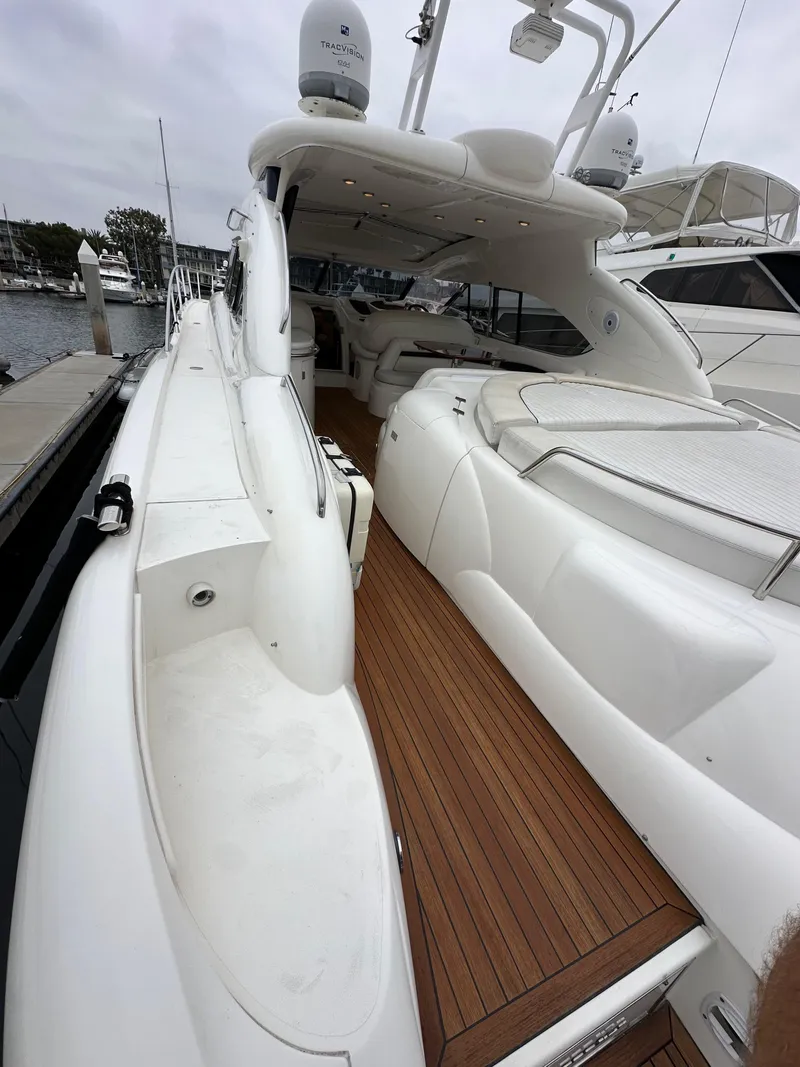 Slide: The Image of Sunseeker Predator 60 yacht, 2000 model, featuring sleek white design and wooden deck. - 12