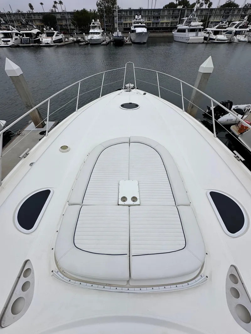 Slide: The Image of Sunseeker Predator 60 yacht bow, docked in marina, showcasing sleek design and spacious deck. - 18