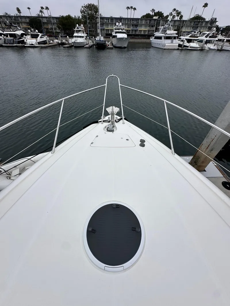 Slide: The Image of Bow view of 2000 Sunseeker Predator 60 yacht in marina, surrounded by boats. - 19